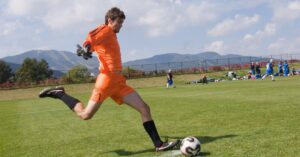 Portero realizando un golpeo largo durante un ejercicio de juego con los pies del portero en entrenamiento de fútbol.